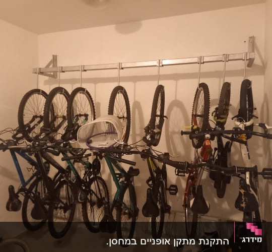 אופניים תלויים על מתלה מתכת על הקיר